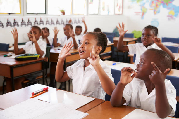 Pupils raising their hands during a lesson at East African Pre & Primary School's
